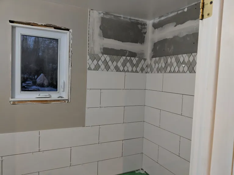 tub surround with accent strip being installed